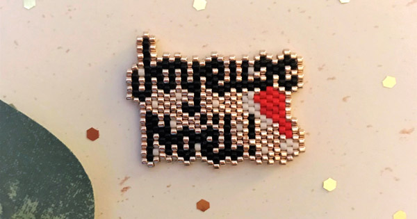 Spilla Joyeux Noël in punto mattone di MamZelle Lulu Spilla Joyeux Noël in punto mattone di MamZelle Lulu