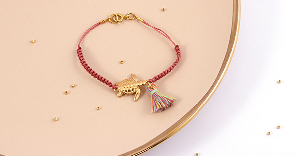 Schema Fai da te Crea un braccialetto macramè con intercalare verde acqua e pompon Schema Fai da te Crea un braccialetto macramè con intercalare verde acqua e pompon