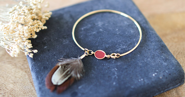 Bracciale rigido dorato con piuma di fagiano Bracciale rigido dorato con piuma di fagiano