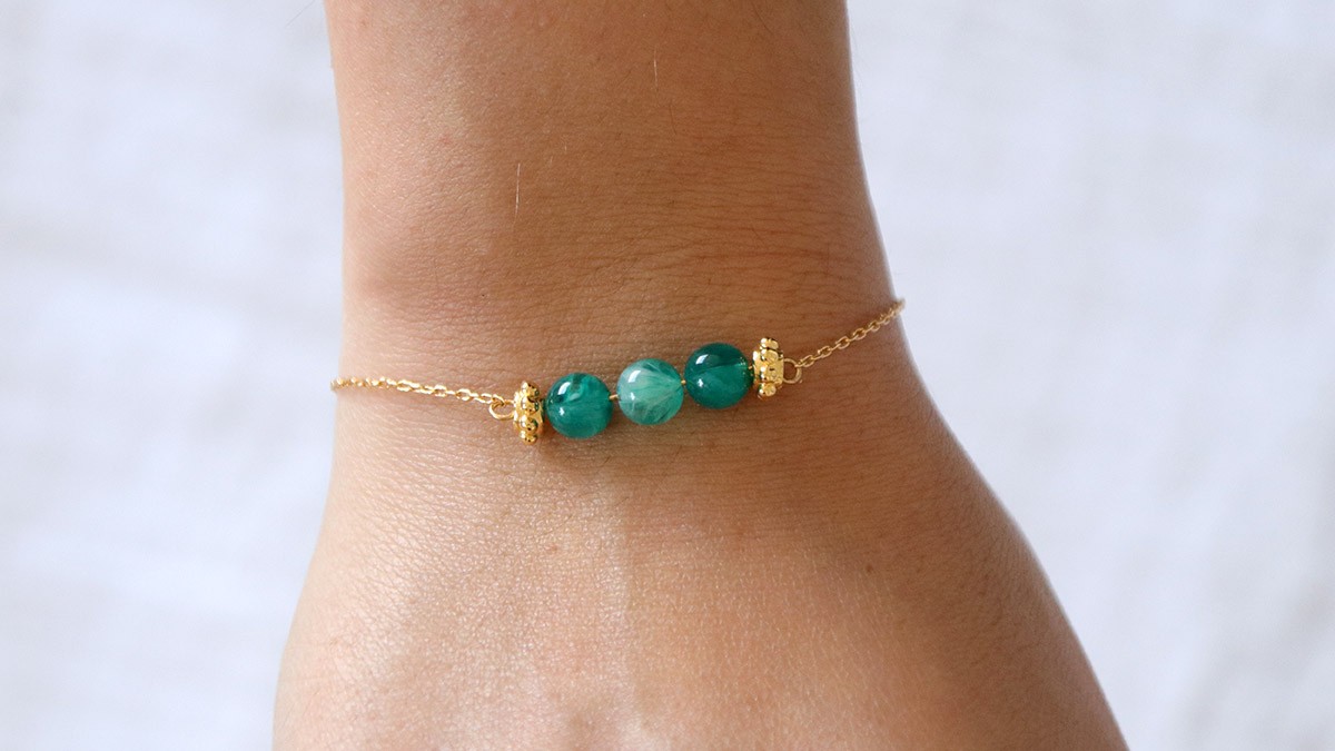 Schema Braccialetto semplice con perline verdi al centro di una catena Schema Braccialetto semplice con perline verdi al centro di una catena