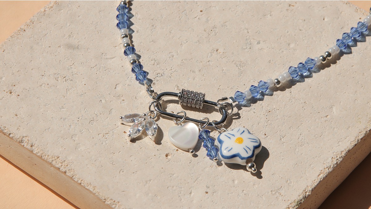 Collana con chiusura a moschettone, trottole blu e accumulo di ciondoli Collana con chiusura a moschettone, trottole blu e accumulo di ciondoli